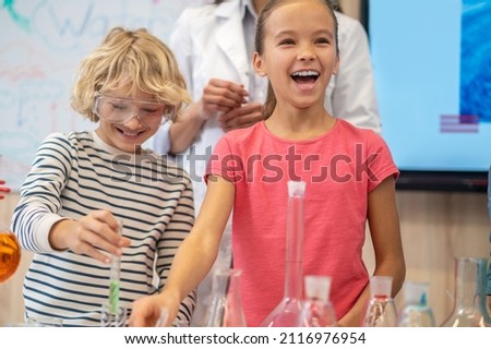Rejoicing girl near table in chemistry class