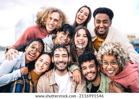 Multi ethnic guys and girls taking selfie outdoors with backlight - Happy life style friendship concept on young multicultural people having fun day together in Barcelona - Bright vivid filter Royalty-Free Stock Photo #2116991546