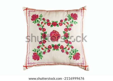 Cross-stitch embroidery in the form of roses on a white linen pillow.