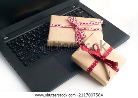 two gift boxes tied with ribbon on a laptop