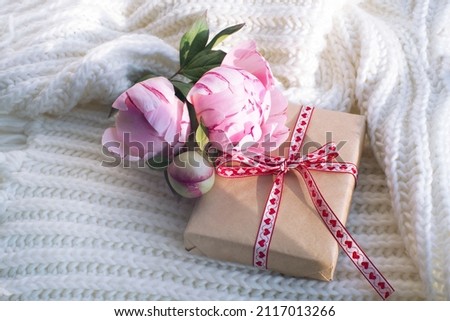 gift box, a bouquet of beautiful peonies on a white knitted scarf. congratulations on Valentine's Day, mother's day, birthday.
