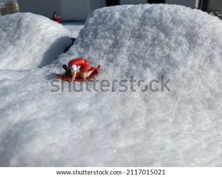 Little  girl figurine doing yoga or sports on a leaf in the snow
