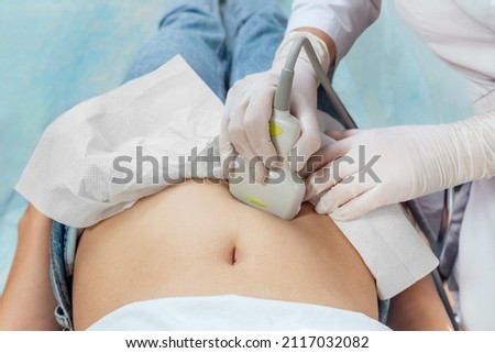 Young woman undergoing ultrasound scan in clinic Royalty-Free Stock Photo #2117032082
