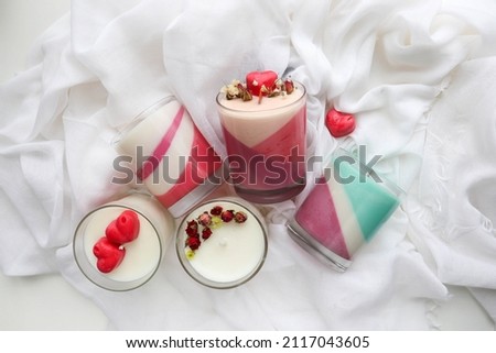 gift concept for valentine's day. aroma candle in a glass of natural soy wax. dry flowers and red heart  Royalty-Free Stock Photo #2117043605