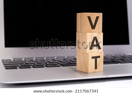 vat - on wooden cubes with letters on a laptop keyboard, vat concept with wooden blocks.