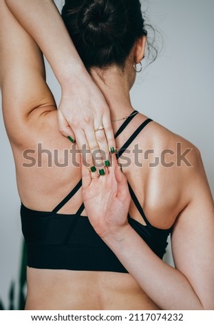 Close Up Photo of An Anonymous Woman Practicing Yoga at Home,  Holding Hands Behind Back in Cow Face Pose  Royalty-Free Stock Photo #2117074232