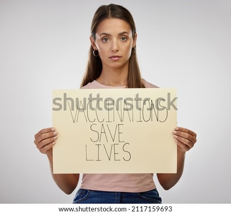 This vaccine is worth a shot. Shot of a young woman standing alone in the studio and holding a poster after getting vaccinated.