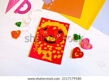 Child making homemade greeting card from paper. Gift for Mothers day, Fathers day, Birthday or Valentines day.  Kid craft. Home Education game. development concept