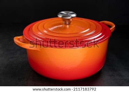 orange dutch oven on wet black surface. Royalty-Free Stock Photo #2117183792
