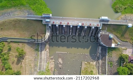 Water in dam concrete spillway infrastructure at reservoir. Waterfall and stream in side channel spillway. Dam with drainage channel Royalty-Free Stock Photo #2117202968