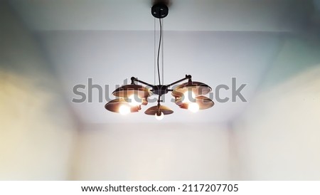Retro-like black cailing lamp hanging from the cailing with white background