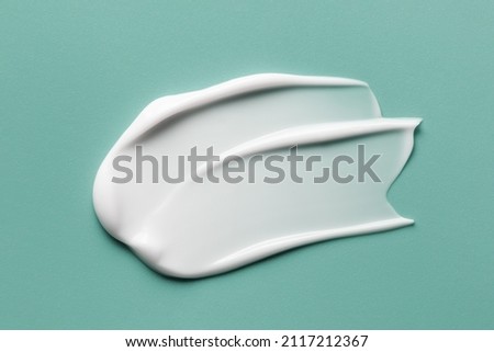 Skincare cosmetic cream lotion swatch smear smudge on mint color background. White creamy hygiene beauty product close up Royalty-Free Stock Photo #2117212367