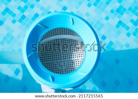 Top view of the blue skimmer for cleaning the pool in clear water. Close-up of the skimmer mounted on a frame pool Royalty-Free Stock Photo #2117215565