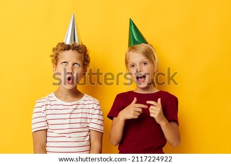 picture of positive boy and girl holiday fun with caps on your head isolated background