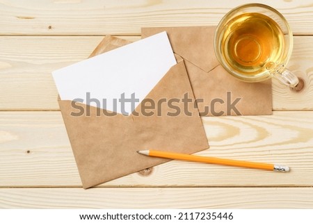 Envelopes with cup of tea on wooden table top view