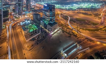 Aerial panoramic view of media city district and highway junction timelapse from Dubai marina. Towers and skyscrapers with traffic on a highway from above