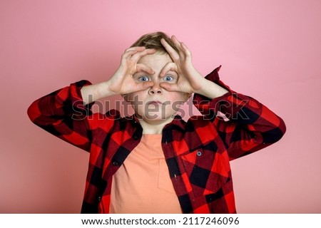 Kid boy make big eyes with fingers. Child make binoculars. Stylish school boy discover future 
