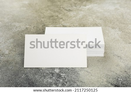 Photo of a stack of blank business cards on a stone table. Template for identity card.