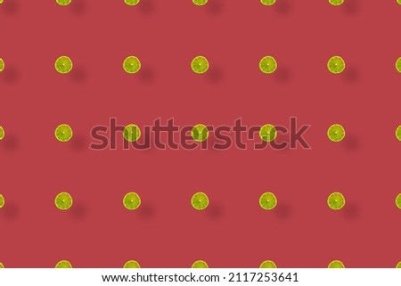 Colorful fruit pattern of fresh limes slices on red background with shadows. Top view. Flat lay. Pop art design