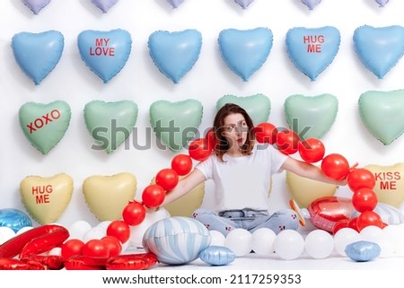 beautiful young woman on many colorful heart balloons background. smiles,funny Valentine s Day birthday party