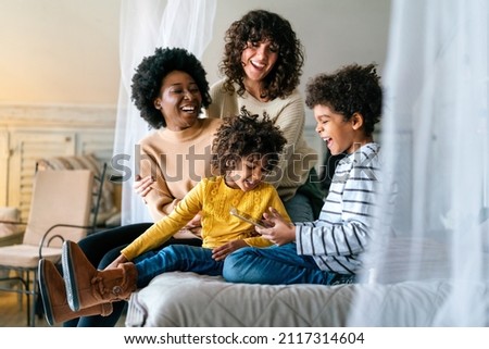 Family children gay parents concept. Happy multiethnic women couple having fun with kids at home Royalty-Free Stock Photo #2117314604