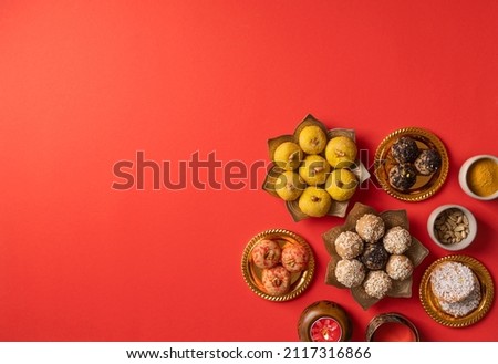 Indian traditional sweets various laddu for festival on red background with copy space, flat lay Royalty-Free Stock Photo #2117316866