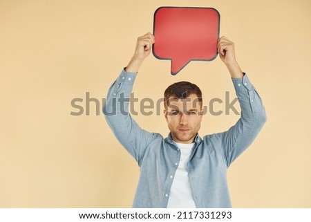 Facial expression. Man standing in the studio with empty signs for the text.