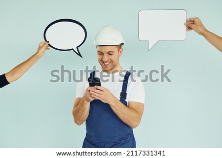 White hard hat and blue uniform. Man standing in the studio with empty signs for the text.