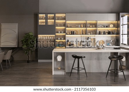 stylish luxury kitchen interior in an ultra-modern spacious apartment in dark colors with super cool led lighting and an island for cooking and a dining table area Royalty-Free Stock Photo #2117356103