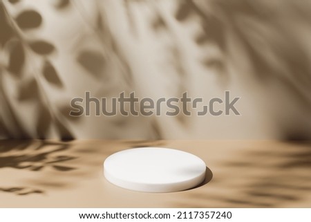 Abstract minimal nature scene - empty stage and white circle podium on beige background and soft shadows of tree leaves. Pedestal for cosmetic product and packaging mockups display presentation