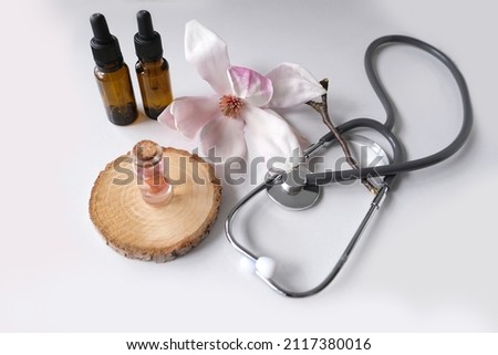 oil, tincture, medical stethoscope, creating a new medicine from plants, gifts of nature, dietary supplements, magnolia flowers, concept science, natural medicine, pharmacology