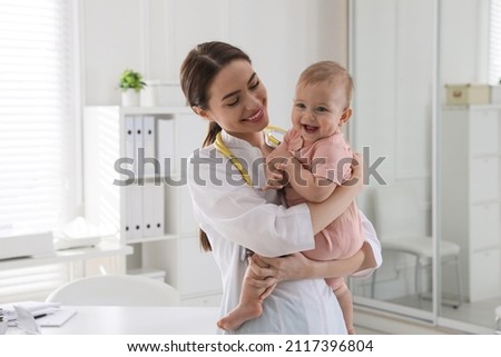 Young pediatrician with cute little baby in clinic Royalty-Free Stock Photo #2117396804