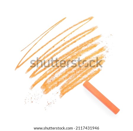 Orange pastel chalk on sheet of paper with scribble, top view. Drawing material