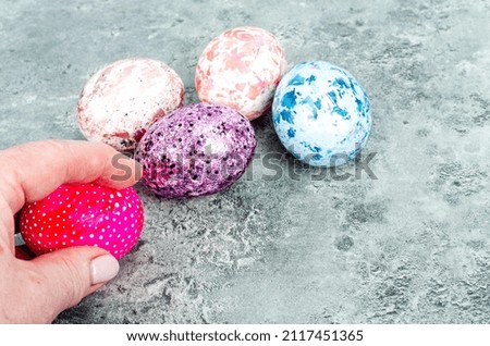 Female hand holding brightly colored easter eggs. Photo