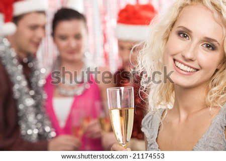 Portrait of beautiful female with champagne looking at camera and smiling