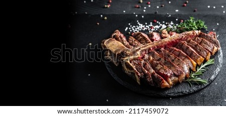 Traditional American barbecue dry aged steak sliced. porterhouse steak sliced as top view on a slate board. banner, catering menu recipe place for text. Royalty-Free Stock Photo #2117459072