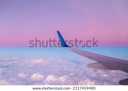Airplane wing view during sunset with fantastic purple colors. Royalty-Free Stock Photo #2117459480