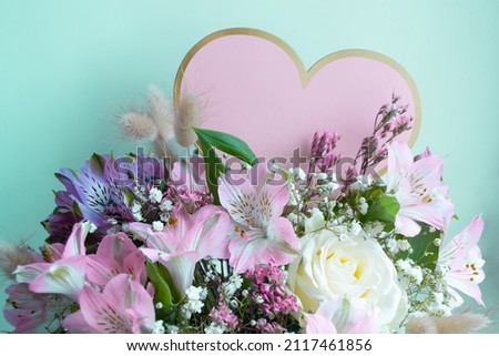 Delicate bouquet pink lilies, white roses, gypsophila. Turquoise background. Pink Heart, copy space