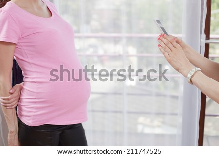 photographing pregnant women mobile phone at home