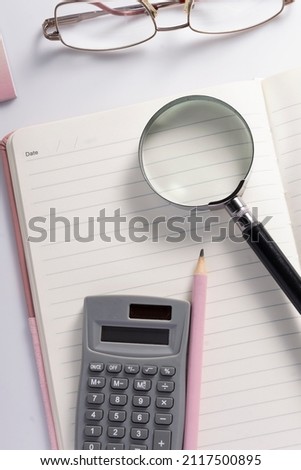 Calculator, glasses, pen and notebook on the table, financial organizer concept
