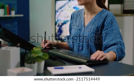 Media artist editing photos using touch screen computer and graphic tablet with stylus at photograpy studio. Photographer with technology and devices working on retouching pictures