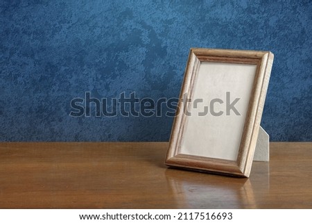 wooden photo frame on table, blue wall
