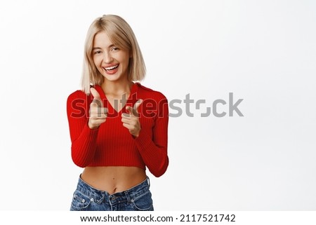 Congrats, great job. Smiling stylish young blond woman praising you, pointing fingers at camera with congratulations, announcing winner, inviting people, white background