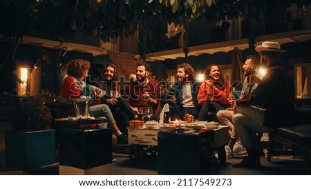 Big Dinner Garden Party Celebration with Friends on a Warm Summer Evening. Beautiful People Enjoy Life on a Terrace, Chat, Relax on Weekend, Have Fun, Drink Wine, Give Toasts and Eat Homemade Food. Royalty-Free Stock Photo #2117549273