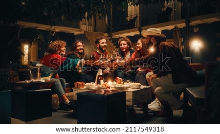 Big Dinner Garden Party Celebration with Friends on a Warm Summer Evening. Beautiful People Enjoy Life on a Terrace, Talk, Relax on Weekend, Have Fun, Drink Wine, Give Toasts and Eat Homemade Food. Royalty-Free Stock Photo #2117549318