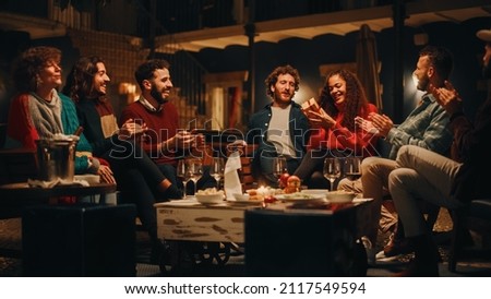 Big Dinner Garden Party Celebration with Friends on a Warm Summer Evening. Beautiful People Enjoy Life on a Terrace, Chat, Relax on Weekend, Have Fun, Drink Wine, Give Toasts and Eat Homemade Food. Royalty-Free Stock Photo #2117549594