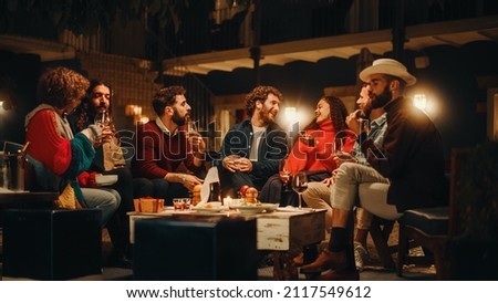 Big Dinner Garden Party Celebration with Friends on a Warm Summer Evening. Beautiful People Enjoy Life on a Terrace, Chat, Relax on Weekend, Have Fun, Drink Wine, Give Toasts and Eat Homemade Food. Royalty-Free Stock Photo #2117549612