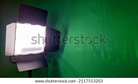 close up view of a video light in front of a green screen with blank space for design. led studio light for photographic, live, social media works. 