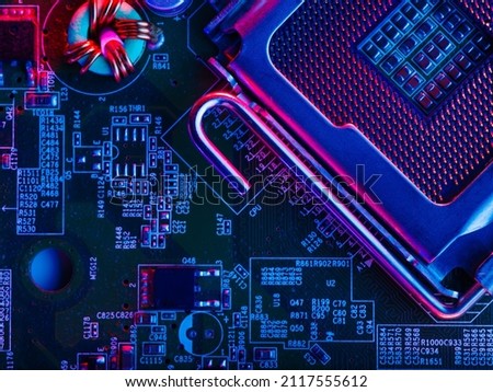 The desktop of the processor lies with the contacts up on the motherboard of a personal computer. macro photography. Neon lighting. Computer component, modern technology, engineering.