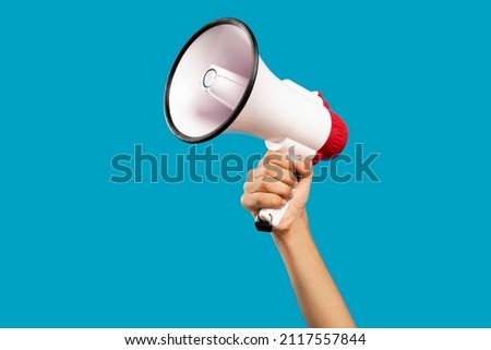 Picture of hand with mouthpiece on empty blue background Royalty-Free Stock Photo #2117557844